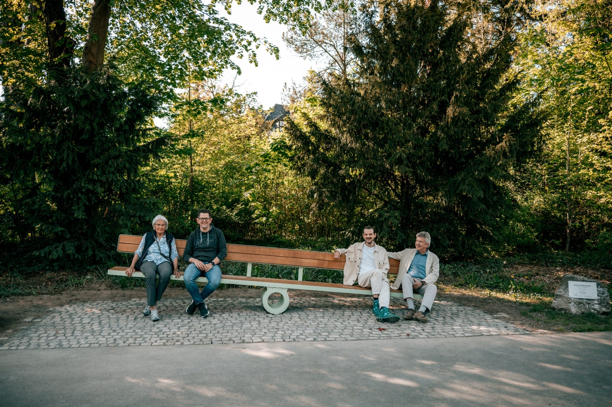 a bench shifts to the right as four people sit on opposite ends